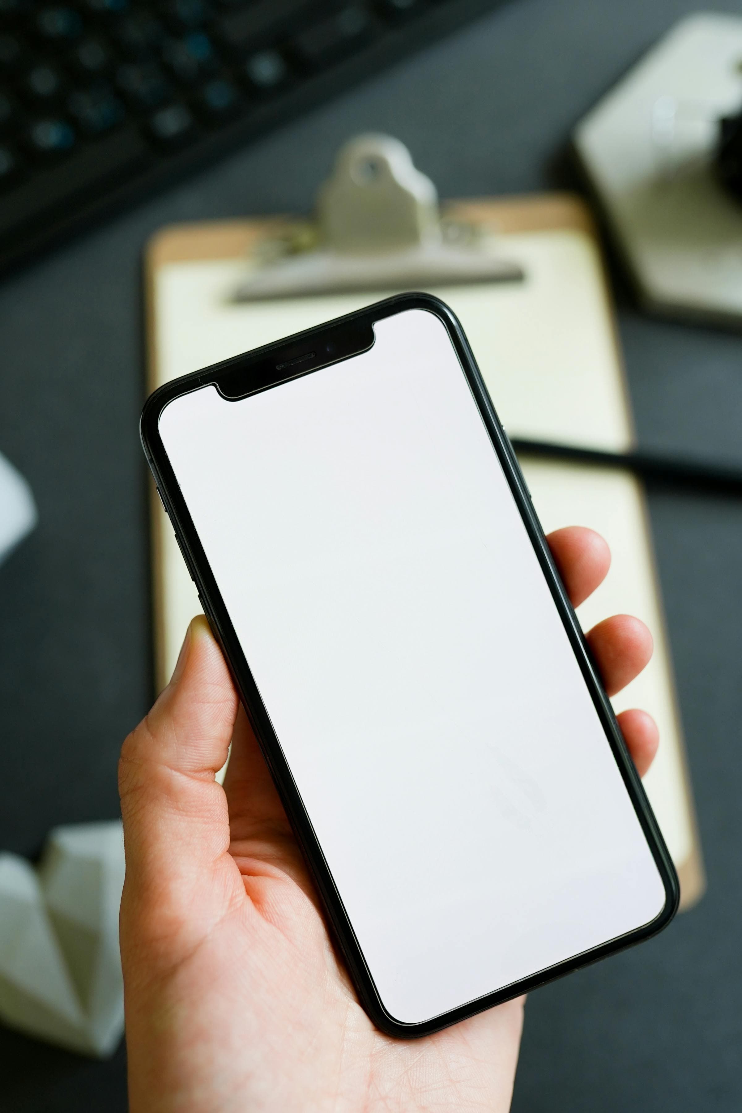 Contractor checking job notes on a phone above a clipboard